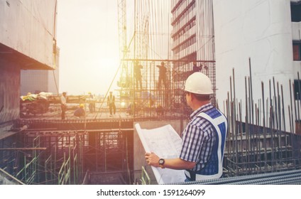 worker builder foreman engineering occupation working with construction site project background. person looking plan paper to made floor business tower building. industry achitecture building concept.