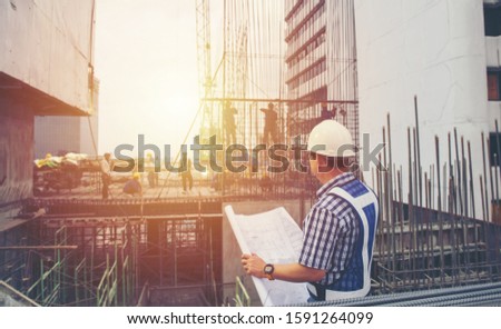 worker builder foreman engineering occupation working with construction site project background. person looking plan paper to made floor business tower building. industry achitecture building concept.
