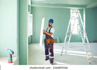 Worker Builder Installs Plasterboard Drywall At A Construction