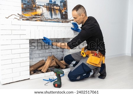 Worker building brick stove or fireplace checking it with spirit level