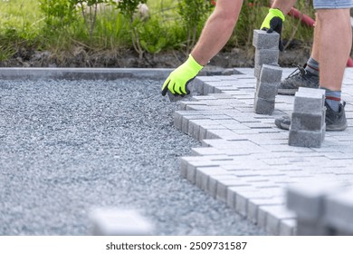 Worker building a new interlocking pavement from concrete paving, a new path building concept