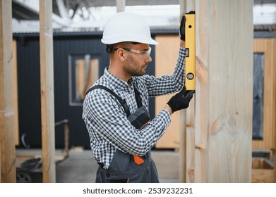 Worker carpenter assembling a modular house.