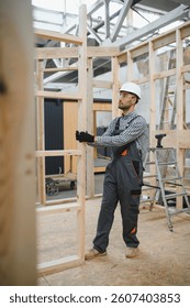 Worker carpenter assembling a modular house.