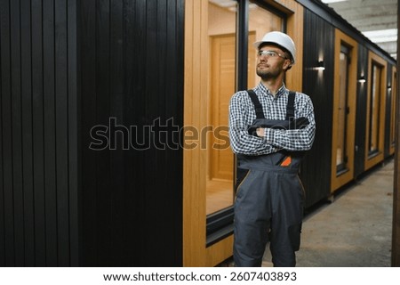 Worker carpenter assembling a modular house.
