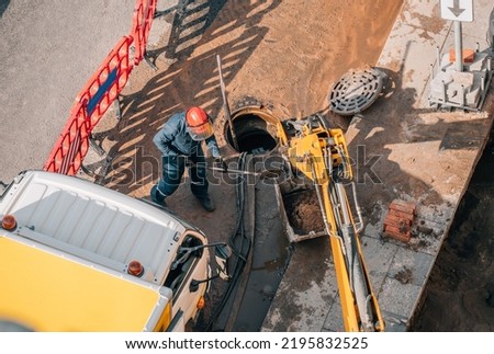 Worker carries out cleaning, repair and maintenance of outdoor street sewers