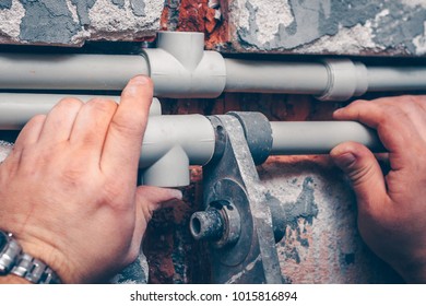 The worker carries out plumbing works in the house, mounts water pipes from polypropylene