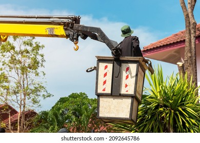 Worker With Chainsaw In Truck Tower Basket Cutting Branches. Tree Surgeon In Lifting Bucket Using Saw To Cut Branches Down. Arborist Remove Tree Branches On Height. Pruning Trees.