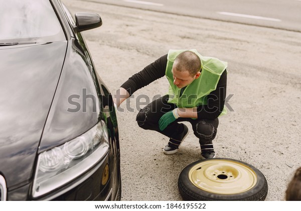 Worker changes a broken wheel of a car. The
driver should replace the old wheel with a spare. Man changing
wheel after a car
breakdown.