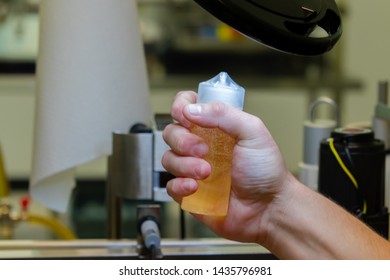 A worker checking a bottle of ejuice.