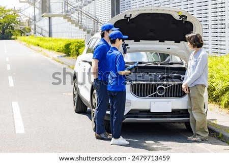 Worker checking the engine compartment of a car. Automobile mechanic.