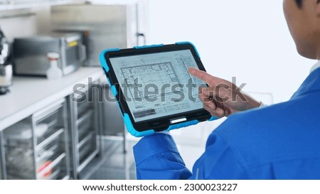 A worker checking the interior design on a tablet.