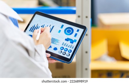 Worker checking inventory on a tablet warehouse management system.