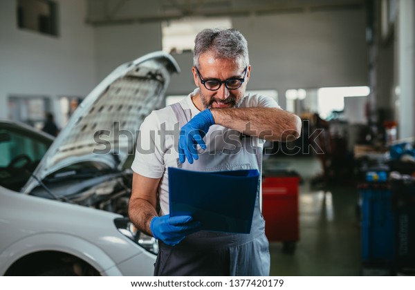worker checking part\
list in car service