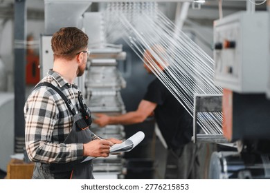 Worker checking production process of polymer threads on industrial loom machine, ensuring quality control in manufacturing