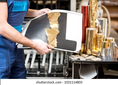 Worker checking the quality of the foil stamping at the manufacturing - Shutterstock ID 1031114803