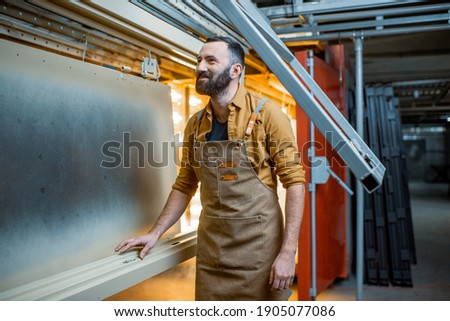 Worker checking the quality of the painted with powder coating metal products Stock photo © 