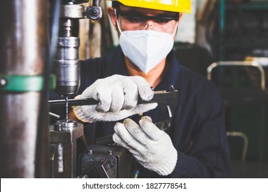 The worker is checking the quality size and design of the metal parts with Vernier Caliper from the metalwork in the factory. The manufacturing metal parts and the checking of quality.