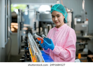 Worker Checking quality or checking stock of glass bottle in beverage factory. Worker QC working in a drink water factory  - Powered by Shutterstock