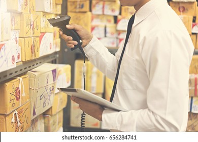 Worker checking and scanning package in warehouse.