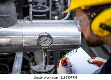 Worker Checking Water Temperature And Pressure In Heating Plant.