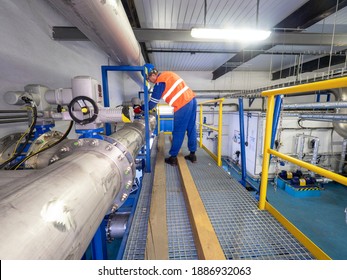 The worker checks the valves behind the compressors of the high-pressure biogas circuit in the cogeneration plant.
