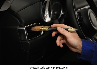 Worker Cleaning Automobile Air Conditioner Vent Grill With Brush, Closeup. Car Wash Service