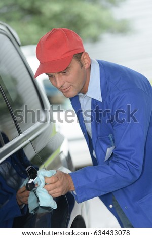 worker cleaning a car