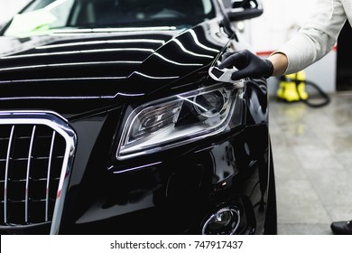 Worker cleaning car - car detailing (or valeting) concept. Selective focus. 