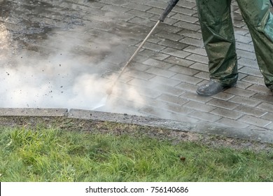 Worker Cleaning Driveway With High Pressure Water Jet, High Pressure Cleaner. High Pressure Deep Cleaning. 