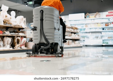 worker is cleaning floor with machine