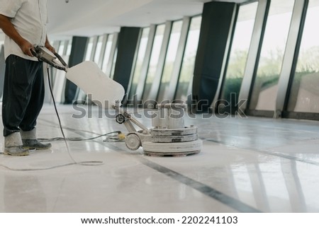 worker is cleaning floor with machine	