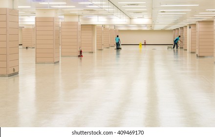 Worker Cleaning Hall Floor Of Office Building