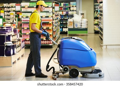 Worker Cleaning Store Floor With Machine