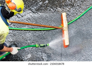 Worker Cleaning With Water Pressure In Construction Site In Street City