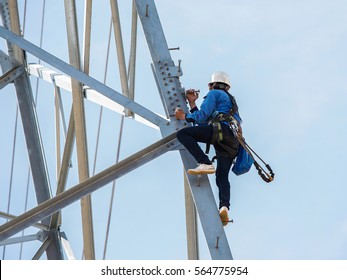 Worker Climbing On Transmission Line Tower