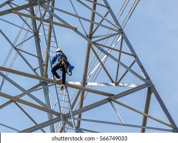 Worker Climbing On Transmission Line Tower