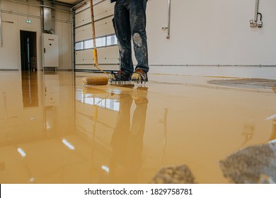 Worker, Coating Floor With Self-leveling Epoxy Resin In Industrial Workshop.