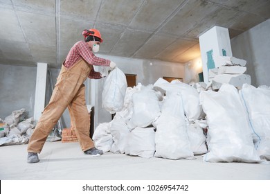 Worker collecting construction waste in bag