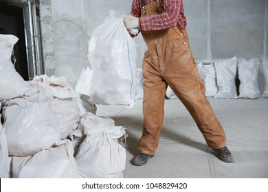 Worker Collecting Construction Waste In Bag