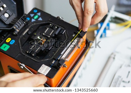 worker comunicate fiber optic cable at opto box. installing new network equipment.