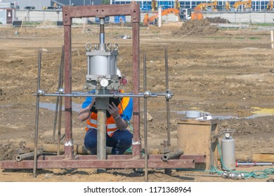 Worker Conducts Environmental Testing Of Soil At The Construction Site