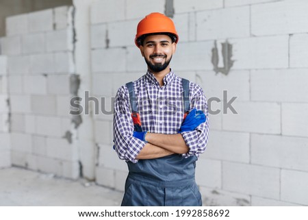 Worker in construction site, Concept proposes to use autoclaved aerated bricks in construction of houses.