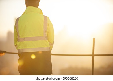 Worker At The Construction Site And Sunrise Background