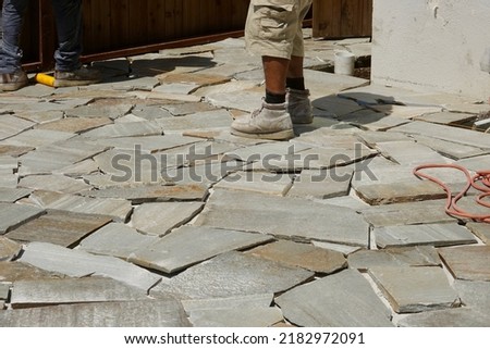 worker contemplating the placement of the next stone