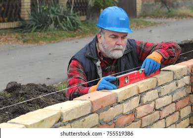 Worker Control Brick Wall Using Level Tool, Real People, No Retouch