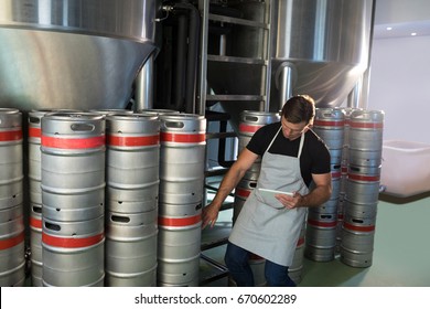 Worker counting kegs at warehouse - Powered by Shutterstock