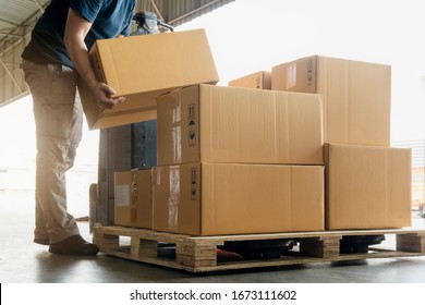 Worker courier lifting package boxes stacking on pallet. Supply chain. warehouse delivery service shipment goods - Powered by Shutterstock