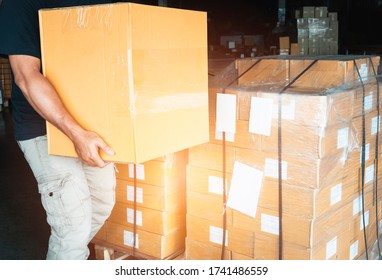 Worker Courier Lifting Shipment Boxes, Packaging, Cardboard Box, Warehouse Delivery Service Shipping Goods At Manufacturing Warehouse.