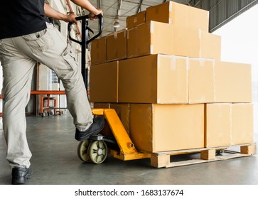Worker courier unloading shipment goods, hand pallet truck and stack package boxes on pallet. Supply chain warehouse delivery service transport and logistics.