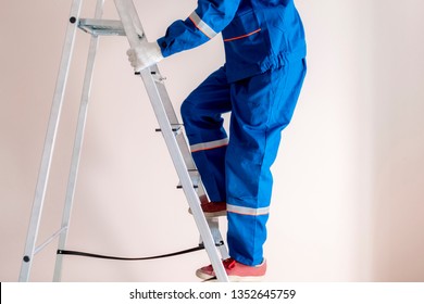 Worker Craftsman Step Up The Ladder To Repair Home 